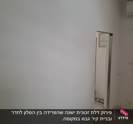 קיר לבן עם פתח דלת וחלק מרצפה